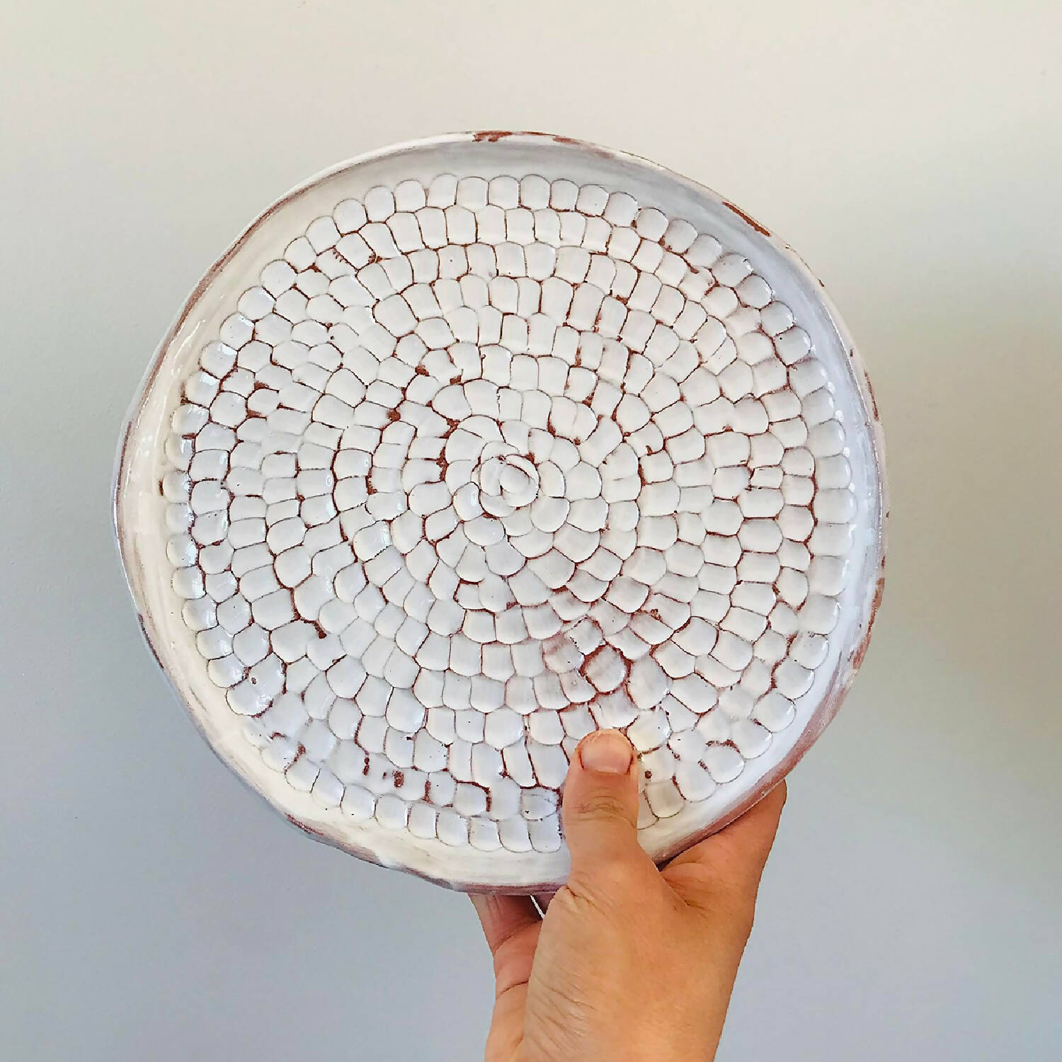 Assiette irrégulière en argile rouge et émail blanc à facettes céramique fait main