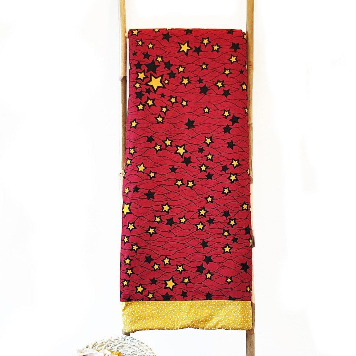 Couverture éco-responsable rouge et jaune en tissu wax avec motifs étoiles