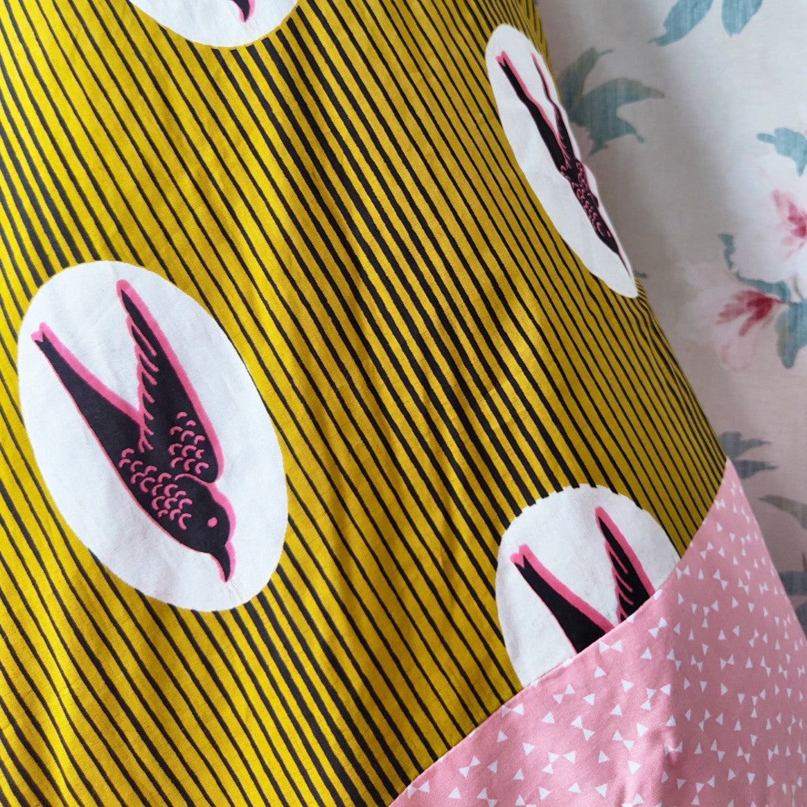 Couverture rose et jaune en tissu wax avec motifs oiseaux