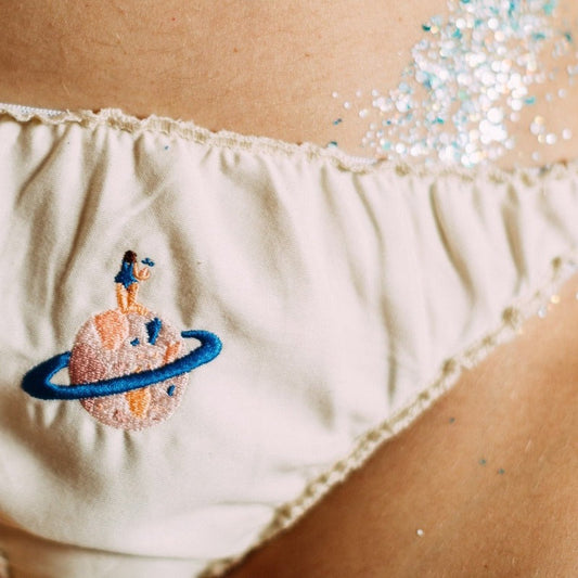 detail broderie artisanale de femme sur une planète